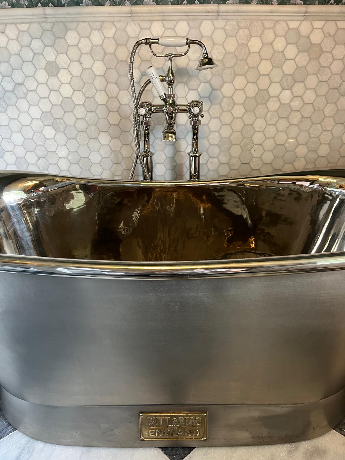 Traditional bath shower mixer in polished nickel over a hand-polished tin bath