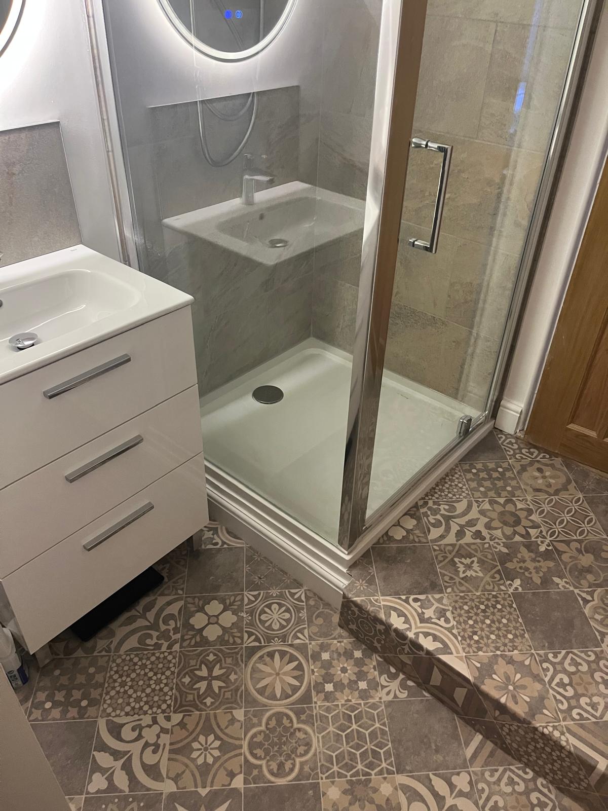 Loft en-suite with Moroccan patterned porcelain floor and corner shower